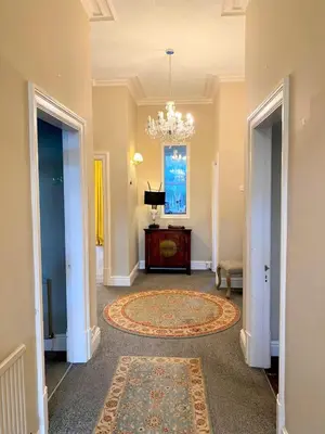 a hallway with a chandelier and a rug at Lyndhurst - Victorian villa with heated pool in Roby