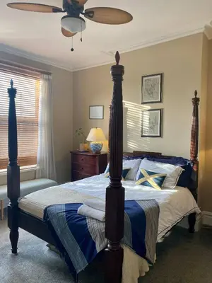 a bedroom with a bed with a ceiling fan at Lyndhurst - Victorian villa with heated pool in Roby