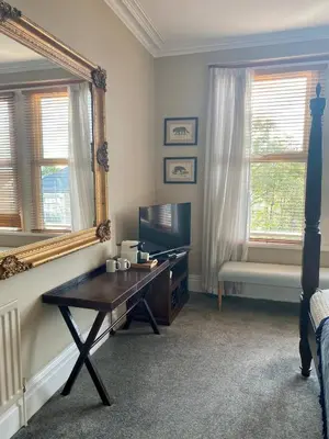 a living room with a mirror and a table at Lyndhurst - Victorian villa with heated pool in Roby