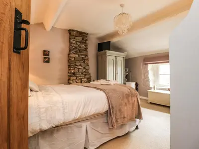 a bedroom with a bed and a stone wall at Duckdown in Clitheroe