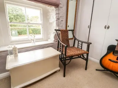 a room with a chair and a table and a guitar at Duckdown in Clitheroe