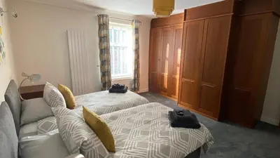 a bedroom with a bed and a couch and a window at Riverside Cottage in Whalley