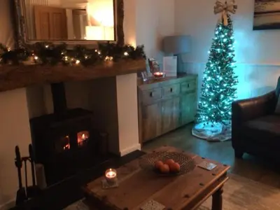 a living room with a christmas tree and a table at Riverside Cottage in Whalley