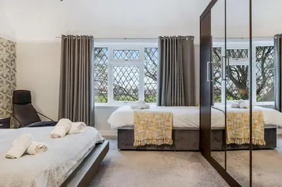 a bedroom with two beds and a mirror at Blackpool Abode - Southlands in Blackpool
