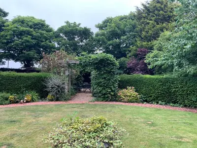 a garden with a bench in the middle of a yard at Blackpool Abode - Southlands in Blackpool