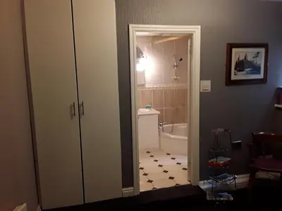 a bathroom with a door open to a bathroom with a tub at The Liverpool Inn Hotel in Liverpool