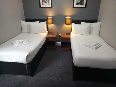 two beds in a hotel room with two lamps at The Liverpool Inn Hotel in Liverpool