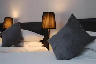 a bedroom with two pillows on a bed with two lamps at The Liverpool Inn Hotel in Liverpool