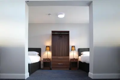 a bedroom with two beds and two lamps on tables at The Liverpool Inn Hotel in Liverpool