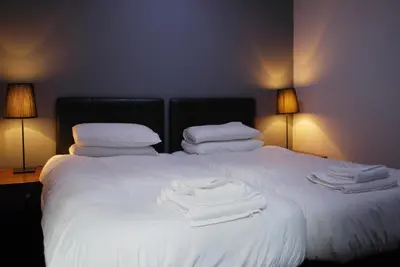 a bedroom with two beds with white towels on them at The Liverpool Inn Hotel in Liverpool