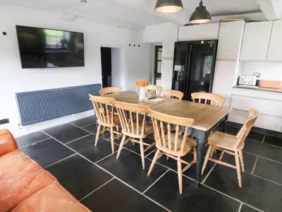 a dining room with a wooden table and chairs at Box Tree Farm House in Lancaster