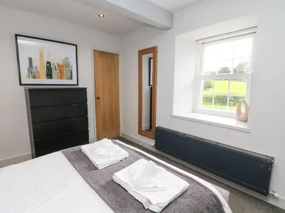 a bedroom with a bed with two white towels at Box Tree Farm House in Lancaster