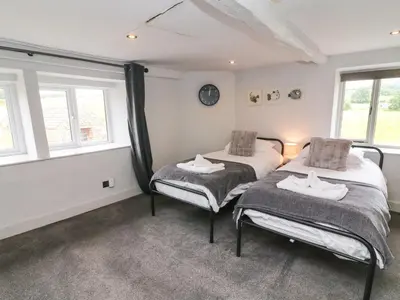 two twin beds in a room with windows at Box Tree Farm House in Lancaster
