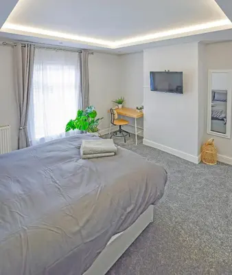 a bedroom with a large bed and a desk at Malleus House in Barrow in Furness