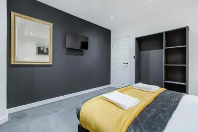 a bedroom with a large bed and a mirror at TWO BED Modern Apartment 5min walk to Town centre with Free Parking ! Under New Management in Blackpool