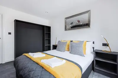 a bedroom with a large bed with yellow and blue pillows at TWO BED Modern Apartment 5min walk to Town centre with Free Parking ! Under New Management in Blackpool