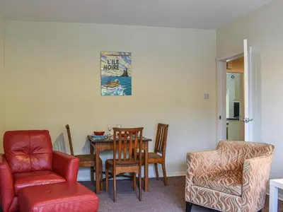 a dining room with a table and a chair at 8 Lowther Gardens in Grange Over Sands