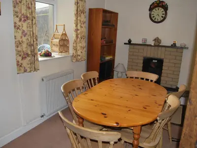 a dining room with a wooden table and chairs at Shore Cottage in Silverdale