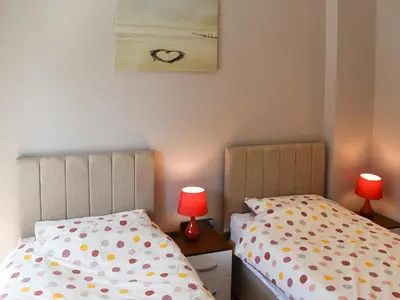 two twin beds in a bedroom with two lamps at Beckside House in Dalton in Furness