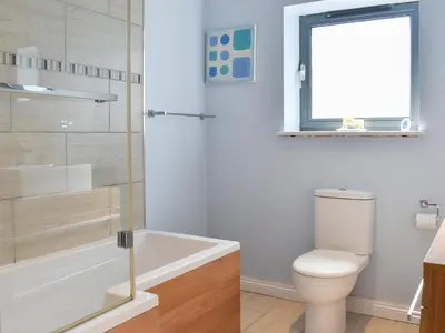 a bathroom with a toilet and a glass shower at Beckside House in Dalton in Furness