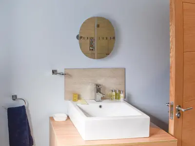 a bathroom with a white sink and a mirror at Beckside House in Dalton in Furness