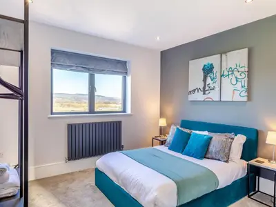 a bedroom with a blue bed and a window at Dewhurst Farm in Langho