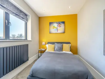 a bedroom with a bed and a yellow wall at Dewhurst Farm in Langho