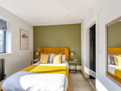 a bedroom with two beds with yellow and green walls at Dewhurst Farm in Langho