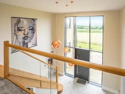 a staircase in a house with a large window at Dewhurst Farm in Langho