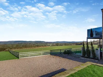 a glass house with a view of a field at Dewhurst Farm in Langho