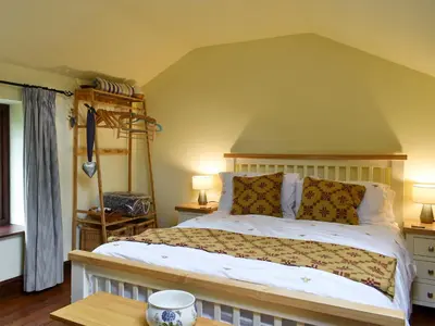 a bedroom with a bed and two lamps and a table at Garden Cottage in Sabden
