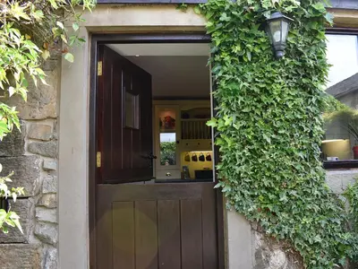 a door with a ivy growing on the side of a building at Garden Cottage in Sabden