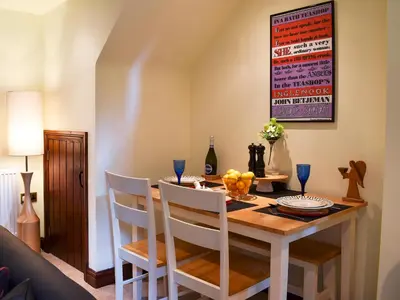 a dining room with a wooden table and chairs at Garden Cottage in Sabden