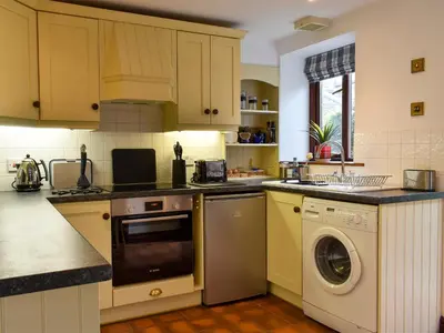 a kitchen with a washer and a dishwasher at Garden Cottage in Sabden