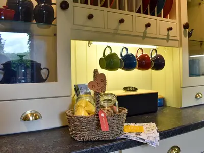 a kitchen counter with a basket of food and utensils at Garden Cottage in Sabden