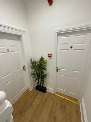 a hallway with two white doors and a potted plant at CityStays Rooms with Free Parking in Liverpool