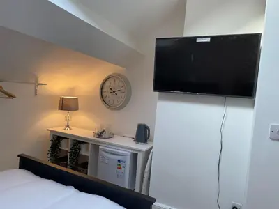 a bedroom with a flat screen tv on a wall at CityStays Rooms with Free Parking in Liverpool