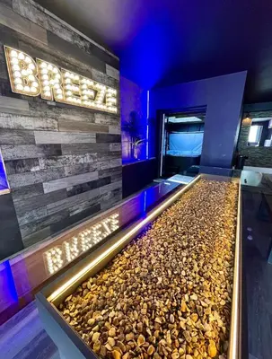 a rock pool in a hotel room with a stone wall at BREEZE SUITES - LUXURY GROUP ACCOM - SLEEPS 19 in Blackpool