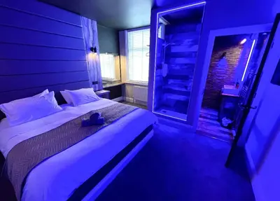 a bedroom with a large bed with a blue light at BREEZE SUITES - LUXURY GROUP ACCOM - SLEEPS 19 in Blackpool