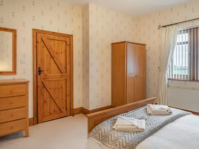 a bedroom with a bed and a wooden door at Highfield Cottage in Poulton le Fylde
