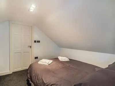 a bedroom with a bed with two towels on it at Highfield Cottage in Poulton le Fylde