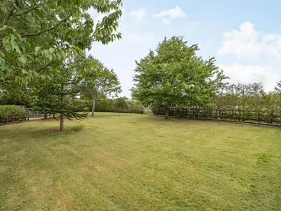 a large yard with two trees and a fence at Highfield Cottage in Poulton le Fylde