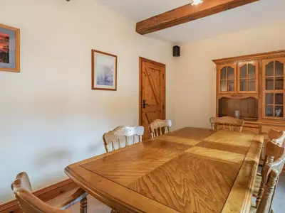 a dining room with a wooden table and chairs at Highfield Cottage in Poulton le Fylde