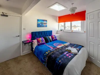 a bedroom with a blue bed and a window at Blackpool Abode - The Cinema House in Blackpool