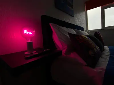 a pink lamp on a table next to a bed at Blackpool Abode - The Cinema House in Blackpool