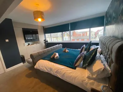 a bed in a room with a couch and a window at Blackpool Abode - The Cinema House in Blackpool