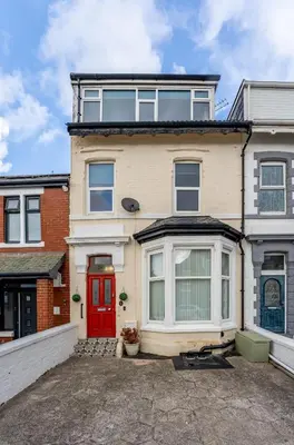 a large white house with a red door at Blackpool Abode - The Cinema House in Blackpool