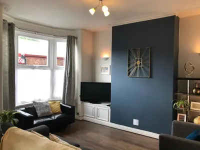 a living room with a couch and a tv on a wall at 3 Bedroom House Close to M6 & M55 in Preston