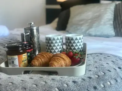 a tray with croissants and strawberries on a bed at 3 Bedroom House Close to M6 & M55 in Preston