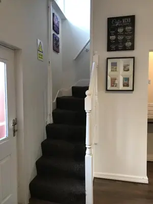 a stairway with a black carpeted stair case at 3 Bedroom House Close to M6 & M55 in Preston